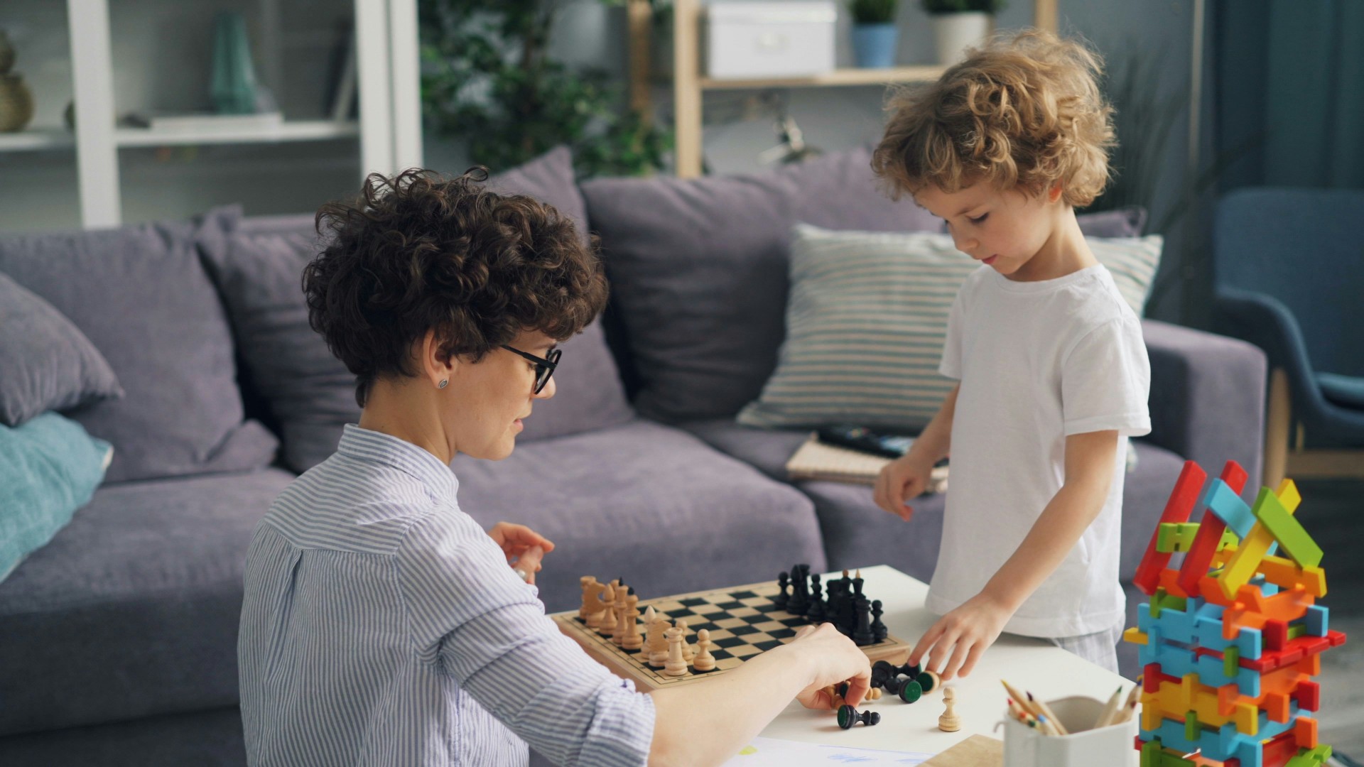 A mother playing chess with her 7 year old son